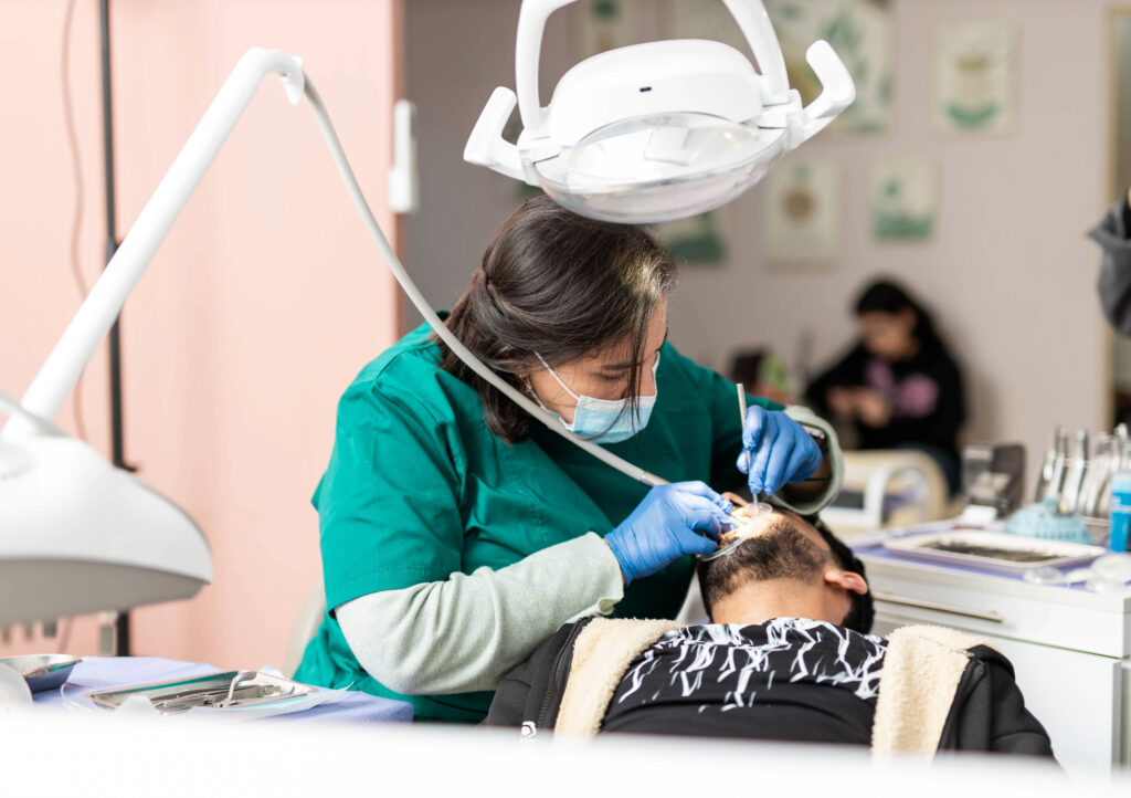 Dr. Moussaoui B. performing a dental treatment at Orthocare Clinic, showing a professional and focused clinical environment